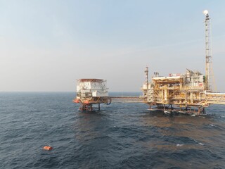 Oceanic Oil Rig A colossal offshore structure dominates the vast expanse of the sea, a testament to human engineering amidst the powerful waves and clear sky.