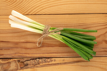 Green fresh onions  on wooden table, top view, macro.