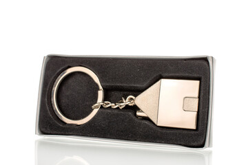 Metal key chain in a box, macro, isolated on a white background.