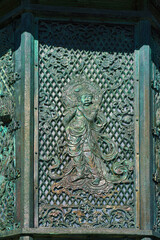 Nara, Japan - Sep 26 2024, vertical, A close-up view of one of the exterior plates of the antique bronze Toro lantern, or Condo doro with various patterns and images, without people, Nara, Japan