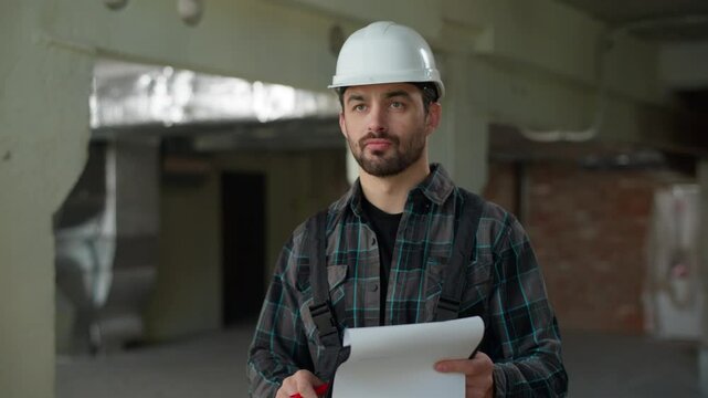 Builder architect engineer man inspecting building on construction site repair work problem dissatisfied foreman writing checklist plan Hispanic guy male technician inspector check build project upset