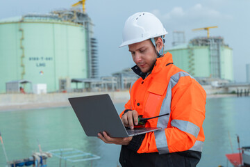 Engineer at LNG Facility Holding Laptop