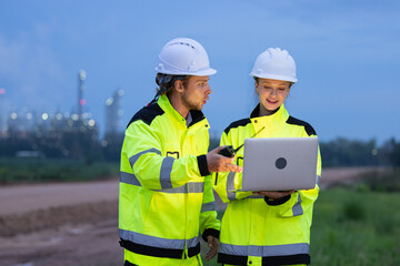 Engineers Reviewing Data at Industrial Site at Night