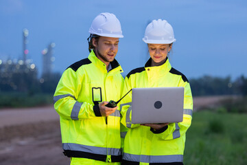 Engineers Reviewing Data at Industrial Site at Night