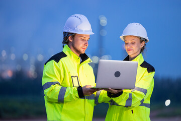 Engineers Reviewing Data at Industrial Site at Night