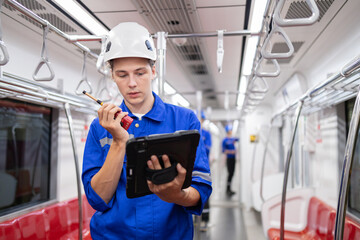 Portrait of young engineer of electric locomotive holding tablet in train