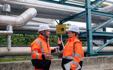 Collaboration between workers at an industrial site during daytime under safety protocols