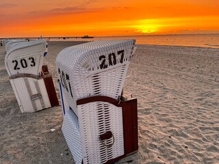 Romantic scene of Beach Chairs at the baltic coastline during sundown in summer