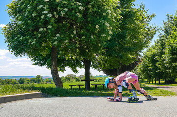The girl fell while rollerblading and is trying to get up. The helmet and knee protection saved me...