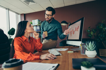 Two professional colleagues collaborating on a workplace project at the office and discussing...