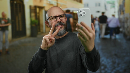 Man with a beard using smartphone in urban street setting gestures enthusiastically while standing...