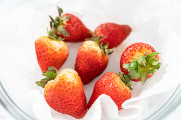 Fresh and Moldy Strawberries in a Glass Bowl on a White Napkin