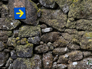 yellow arrow pointing into the direction of the pilgrimiage in portugal on the camino de Santiago,...