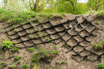 A geogrid reinforces soil on a slope. Geogrid made of polymeric material is a geosynthetic material used to reinforce soils and similar materials