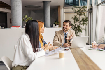 Group of businesspeople sitting around conference table and having briefing.