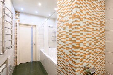 well-lit bathroom features a tub with a shower curtain, a heated towel rack, and a striking mosaic...