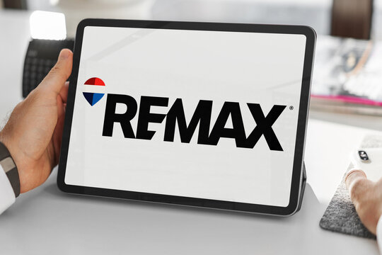 Businessman holding tablet showing re/max logo in office