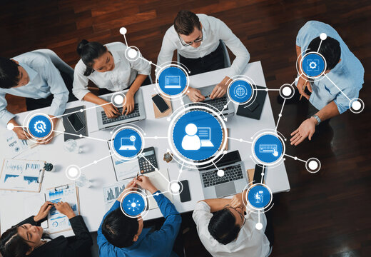A dynamic business meeting showcases diverse professionals collaborating around laptops, with a technology interface overlay symbolizing innovation and digital solutions. Amity