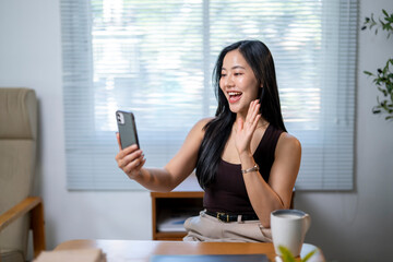 A woman is smiling and taking a picture of herself with her cell phone
