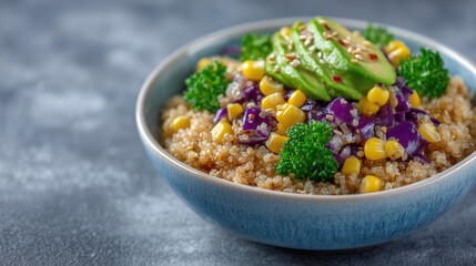 Vibrant vegan Buddha bowl features quinoa, sliced avocado, and assorted veggies. Bright colors shine under natural light. Concept of healthy eating, vegan cuisine, nutrition