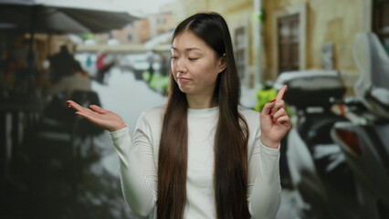 Woman expressing disapproval on a city terrace with open palm, suggesting no in an outdoor urban...