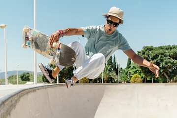 Skater jumping with skateboard in skatepark performing trick © pacoocimage