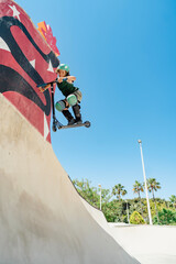 Scooter rider performing trick in skate park