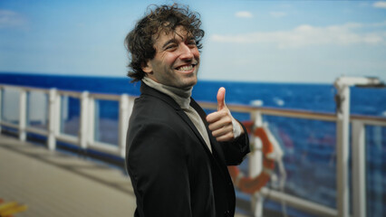 Young man giving thumbs up on a cruise ship with a seaside view, exuding happiness and confidence outdoors while enjoying a pleasant day.