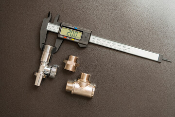 Measuring the diameter of plumbing adapters with an electronic digital caliper, closeup, top view. Plumbing repair concept