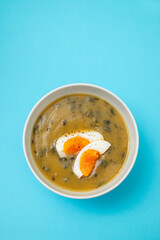 vegetable cream soup with egg in white bowl