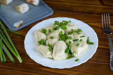 Delicious Ukrainian dumplings with steam and green onions