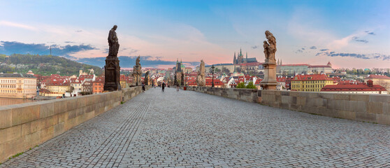 Charles Bridge with towers and sculptures at dawn in Prague, Czech Republic