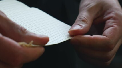The man carefully folds a sheet of paper in half.
The man gives me the paper and folds it.
A sheet of paper, close-up, in the hands of an office worker.
bend, crumple, torn out