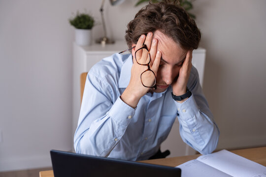 Employee showing mental fatigue and work stress, tired and frustrated with a headache