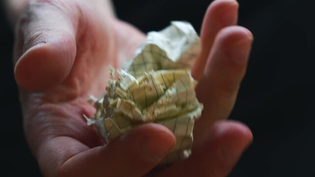 A paper ball with crumpled paper in the hands of an office worker.
A man crumples paper torn from a notebook.
Crumpled and torn paper in hands