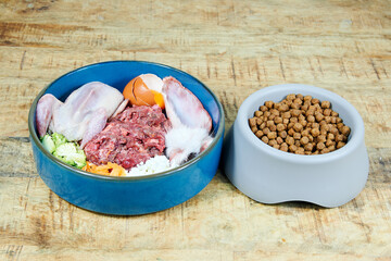 Dog food Natural raw dog food and kibble in bowls on wooden background