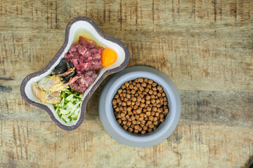 Dog food Natural fresh raw dog food and kibble in bowls on wooden background Top view