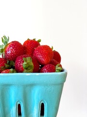 Fresh Strawberries in Blue Ceramic Basket Against White Background

