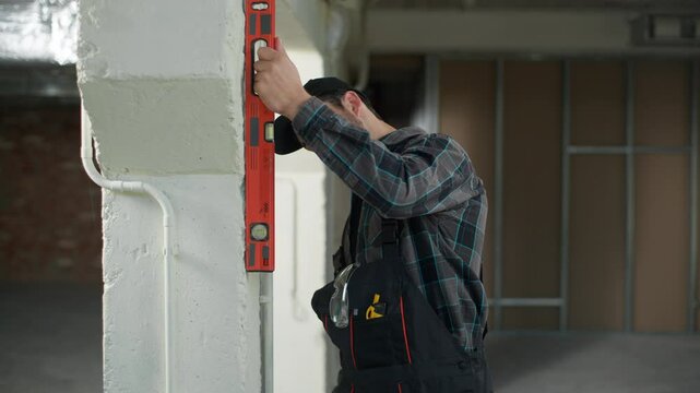 Builder engineer Caucasian man measuring wall with ruler on construction site think doubt problem building apartment renovation male foreman architect repair mistake confused trouble wrong measure