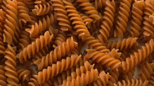 Pile of raw fusilli pasta on table. Italian pasta, pasta spiral texture, top view on raw pasta.
Traditional Italian food.
Fettuccine, tagliatella, spaghetti, boiled, raw