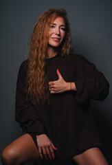Young smiling woman showing thumbs up studio portrait
