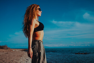 Young beautiful fitness woman portrait on lake shore on sunny day
