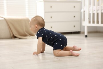Cute little baby crawling on floor at home