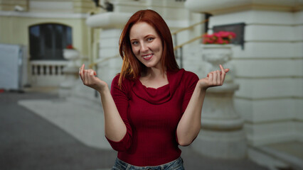 Woman smiling and making money gesture outdoors in urban city street, showcasing joy and confidence...