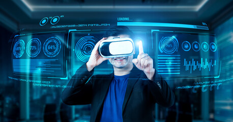 Project manager with VR goggles pointing financial chart and glowing blue light at office. Skilled businessman checking and planning marketing strategy by using data from augmented reality. Ingenuity.