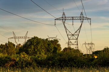 High voltage pylon in the French countryside at sunset. 400 kV High voltage electric power grid.
