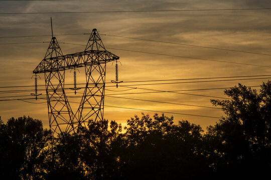High voltage pylon in the French countryside at sunset. 400 kV High voltage electric power grid.