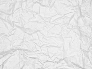 Crumpled and textured white paper with multiple folds and wrinkles creating an abstract pattern. The varying shades of white add depth and dimension to the overall presentation