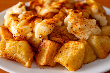 Close-up of patatas bravas with aioli and spicy paprika, a typical Spanish dish