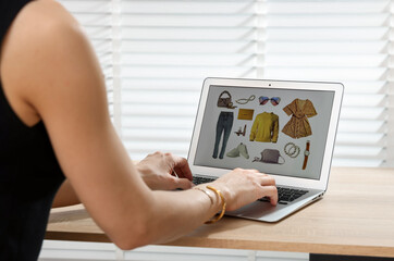 Professional stylist making collage with outfit on laptop at desk indoors, closeup